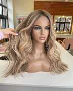 Blonde wig on a mannequin head with a blurred salon background