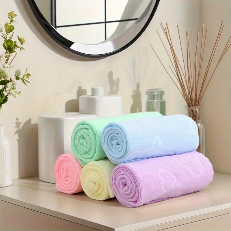 Stack of colorful towels on a shelf with decorative items in the background