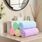 Stack of colorful towels on a shelf with decorative items in the background