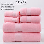 Set of pink towels including washcloths, hand towels, and bath towels on a light gray background.