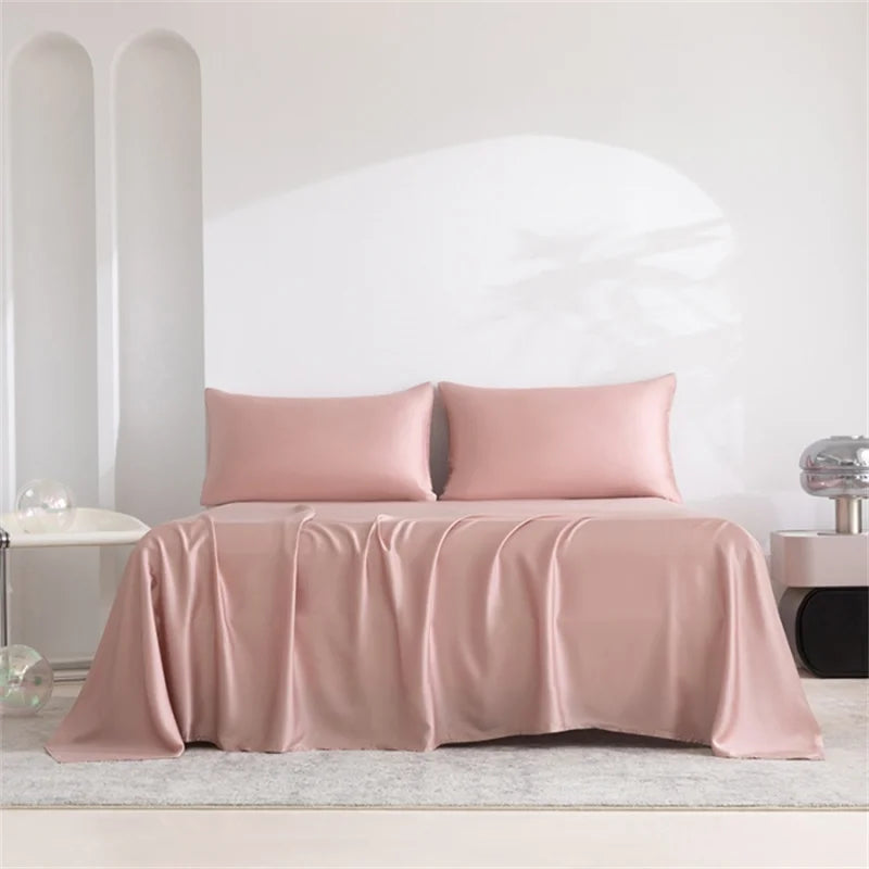 Pink satin sheet set on a bed with a minimalistic background