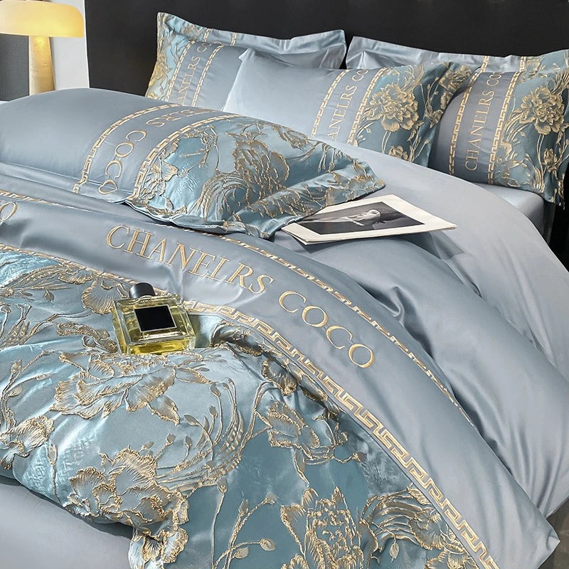Luxury bedding set with floral patterns and 'CHANELS COCO' text on a bed.