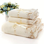 Set of white towels with gold lace detailing on a white background