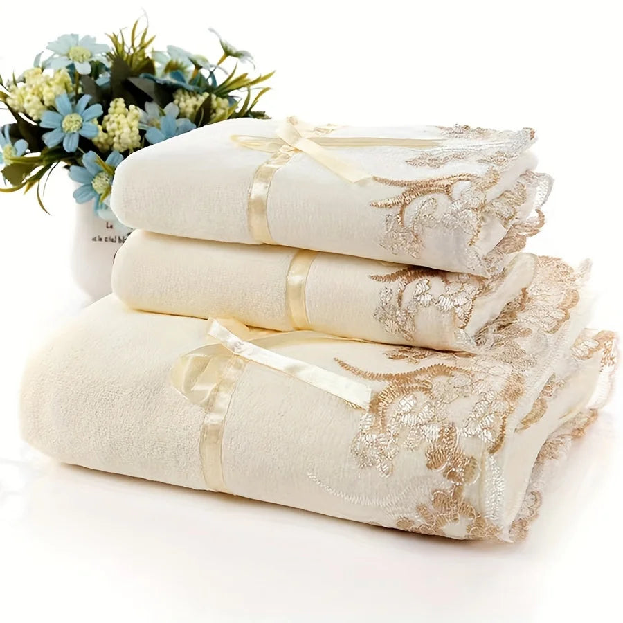 Set of white towels with gold lace detailing on a white background