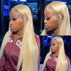 Person with long blonde hair wearing a maroon jacket with white text.
