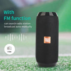 Black portable speaker with FM function on a grassy background