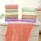 Stacks of colorful towels on a white surface with a neutral background