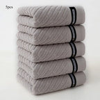Stack of five gray towels with black bands on a white background
