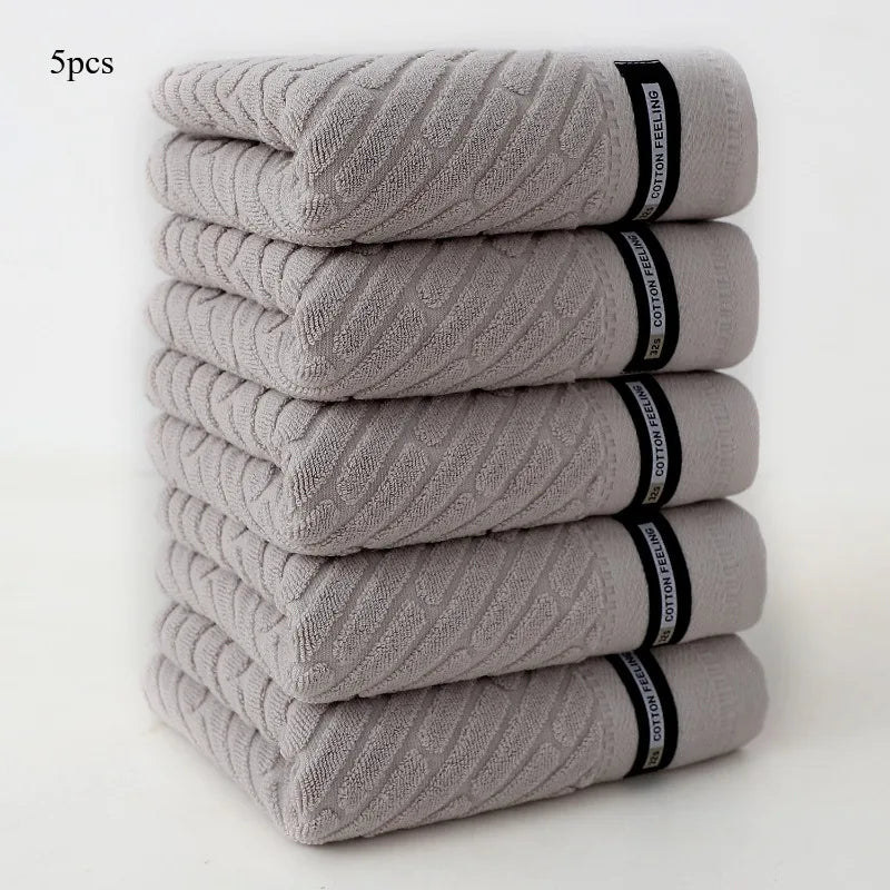 Stack of five gray towels with black bands on a white background