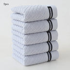 Stack of five gray towels with black labels on a white background