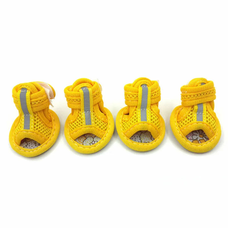 Four yellow dog boots with reflective stripes on a white background