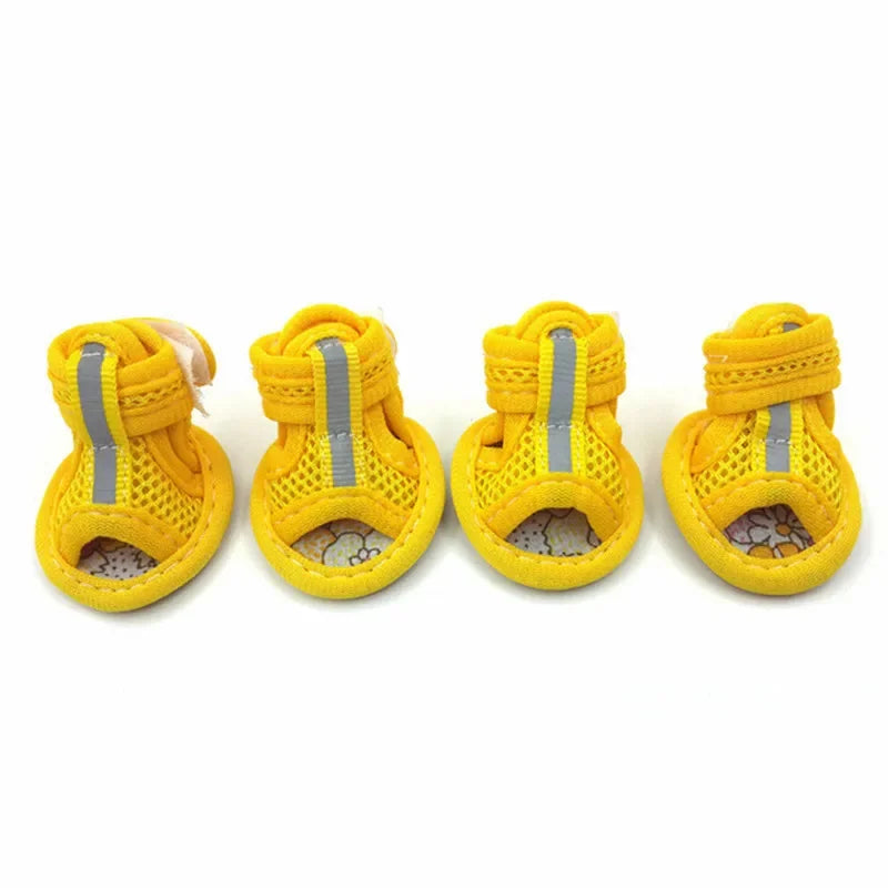 Four yellow dog boots with reflective stripes on a white background