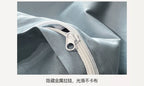 Close-up of a gray fabric with a white zipper, showing smooth texture.