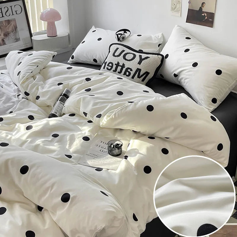 White bedding set with black polka dots on a bed, featuring a close-up of the fabric texture.