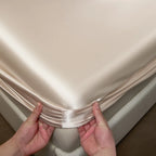 Person holding a folded piece of satin fabric against a neutral background
