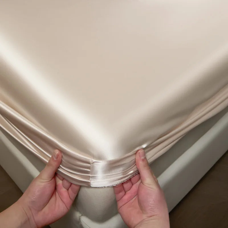 Person holding a folded piece of satin fabric against a neutral background