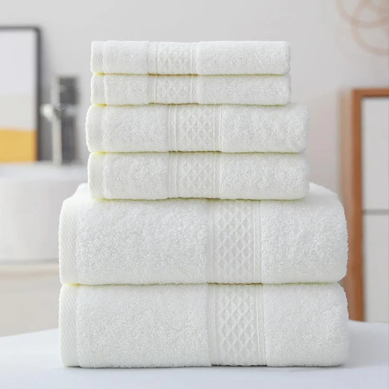 Stack of white towels on a surface with a blurred bathroom background