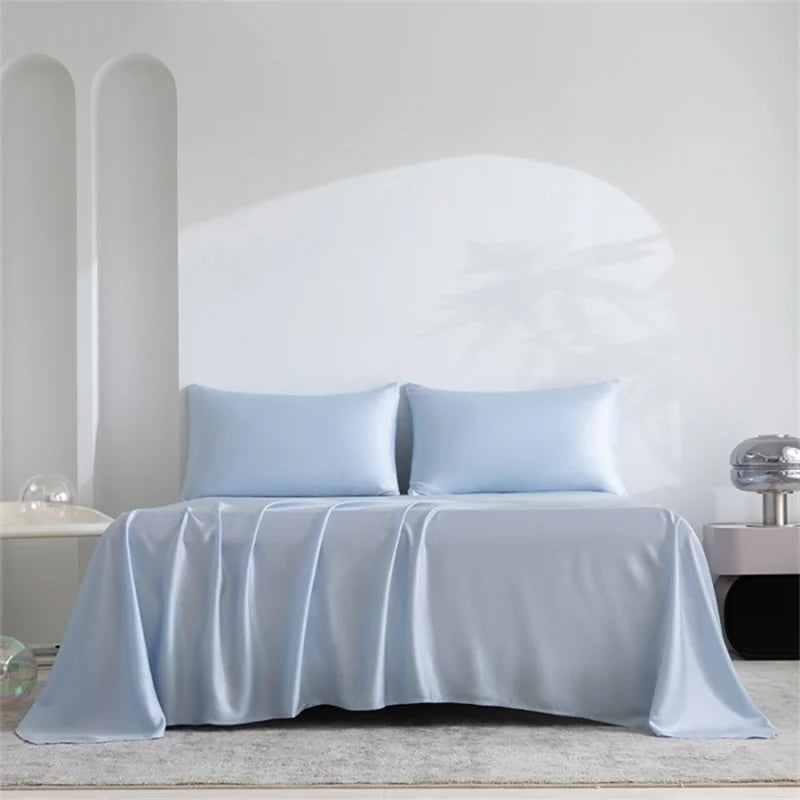 Light blue satin sheet set on a bed with a neutral background