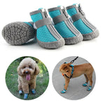 Blue pet boots with gray straps and soles, shown on a white background with two dogs wearing them.