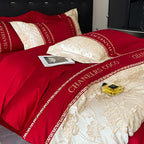 Red and gold bedding set with 'Chanelers Coco' branding on a bed.