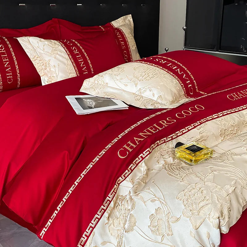 Red and gold bedding set with 'Chanelers Coco' branding on a bed.