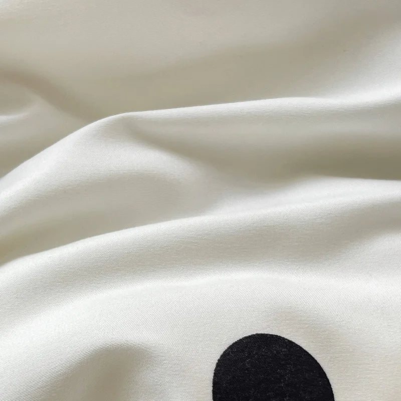 Close-up of white fabric with a black dot