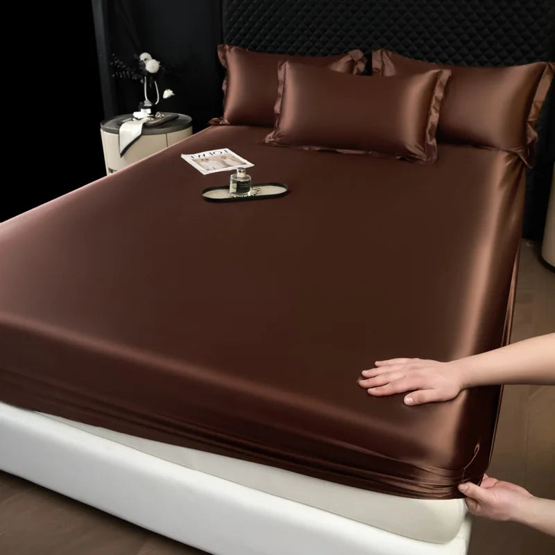 Brown satin sheet set being adjusted on a bed in a bedroom setting.