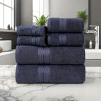 Stack of navy blue towels on a marble countertop with a bathroom setting in the background.