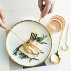 Plated dish with sliced chicken and rosemary garnish, served on a white plate with gold rim and cutlery.