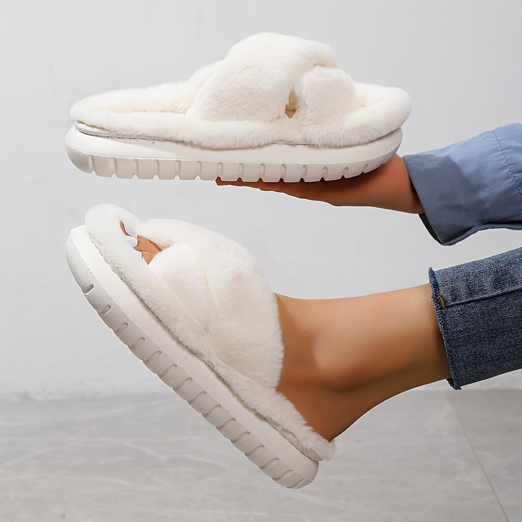 White fluffy slippers being held above a person wearing jeans on a light gray background