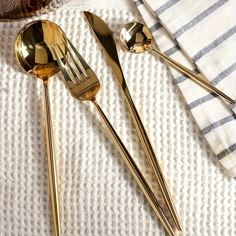 Gold cutlery set on a textured white surface with a striped cloth.